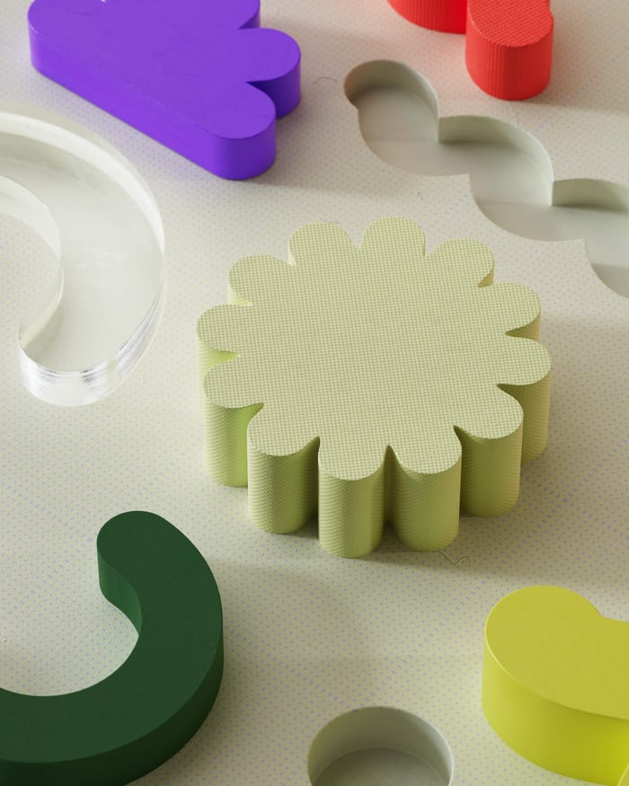 Vibrant abstract composition with colorful geometric 3D shapes on a textured surface.
