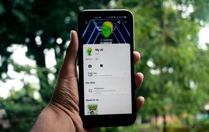 A person holds a smartphone displaying an AI application in a green outdoor setting.