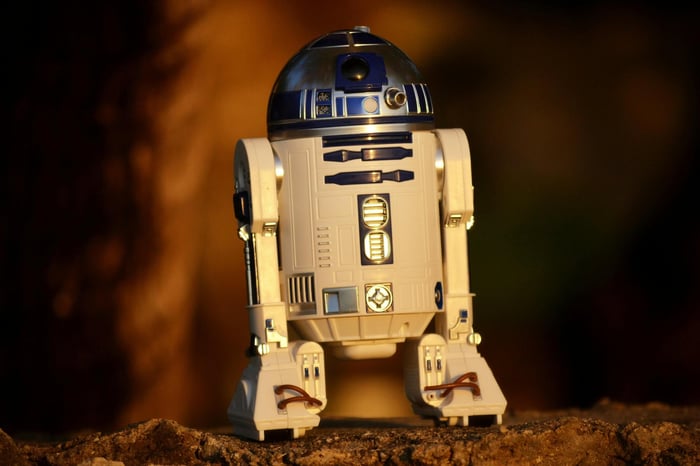 Close-up of a futuristic robot toy outdoors, showcasing its metallic and plastic components.